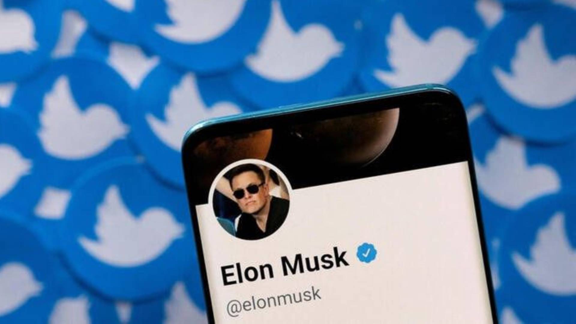  Elon Musk's Twitter profile is seen on a smartphone placed on printed Twitter logos in this picture illustration taken April 28, 2022. REUTERS/Dado Ruvic